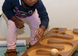 Park West (8) - web Children practicing balance and coordination through a Montessori walking on the line activity.